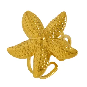 Bague en acier inoxydable dorée en forme d'étoile de mer avec des détails de surface.