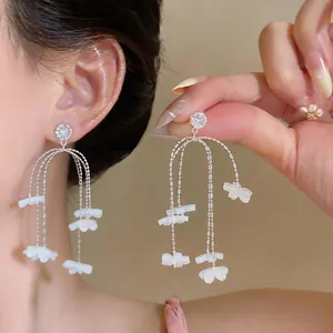 Detailansicht der eleganten Gänseblümchen-Quastenohrringe aus Harz für einen Sommer-Look