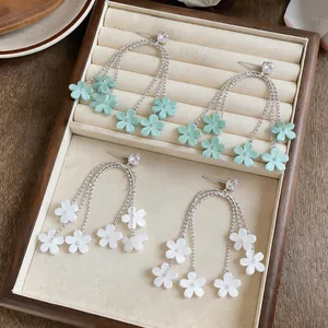 Detailansicht von eleganten Gänseblümchen-Ohrringen mit Harzblüten in Minze und Weiß.