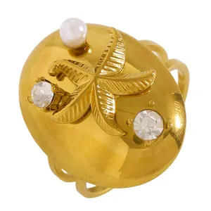 Détail élégant d'une bague étoile de mer dorée en acier inoxydable avec perle et zircons incrustés