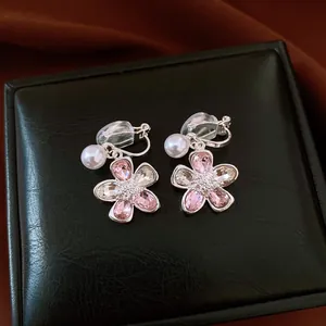 Macro detail view of elegant flower clip-on earrings with pink crystals and pearls