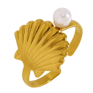 Vue détaillée d'une bague coquillage dorée ornée d'une délicate perle blanche