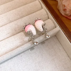Close-up of sweet strawberry-shaped earrings with sparkling zircon drops in a jewelry box