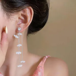 Elegante lange Gänseblümchen-Ohrringe mit weißen Harzblüten im Detail