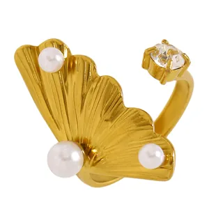 Gros plan d'une bague feuille de ginkgo en acier doré avec perles et zircon brillant
