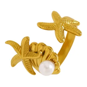 Gros plan d'une bague dorée thème océan avec étoile de mer, coquillage et perle