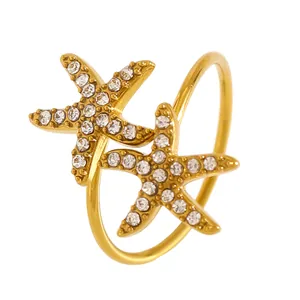 Détail d'une bague en acier doré ornée de deux étoiles de mer en cristal étincelant