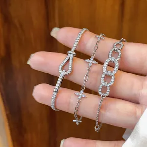 Primo piano di tre braccialetti con zirconi, incluso lo stile con fibbia a ferro.