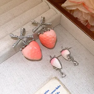Detailed view of sweet pink strawberry stud earrings with sparkling cubic zirconia accents.