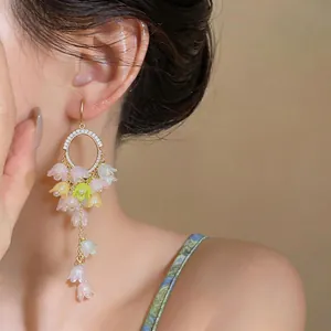 Detailed view of elegant long tassel earrings featuring colorful resin flower charms