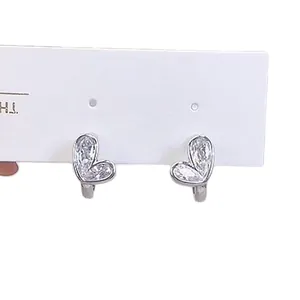 Elegant silver heart-shaped huggie earrings featuring sparkling cubic zirconia stones