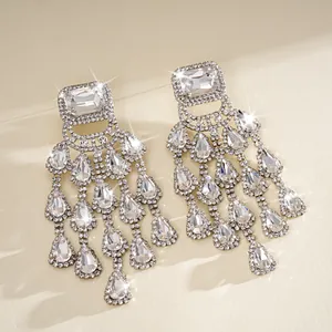 Detailed view of silver-tone chandelier earrings with sparkling square and teardrop rhinestones