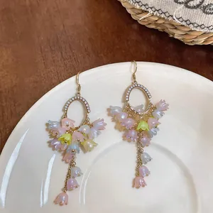 Exquisite close-up detail of lily of the valley dangle earrings with pastel floral tassels