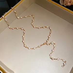 Elegant gold chain necklace featuring white acrylic pearl beads in a vintage style.