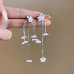 Detaillierte Ansicht eleganter Gänseblümchen-Quastenohrringe aus weißem Harz mit Ketten