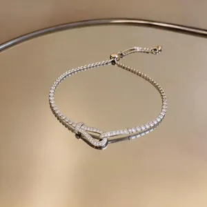 Elegante bracciale con fibbia a ferro di cavallo, zirconi e catena a trazione regolabile