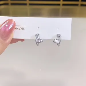 Close-up of elegant silver heart-shaped hoop earrings with clear zirconia stones