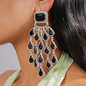 Close-up detail view of elegant black rhinestone chandelier earrings worn by a model.