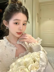 Close-up of elegant sparkly full-diamond bow-knot pearl earrings worn by an Asian model