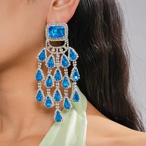 Detail view of blue crystal chandelier earrings with teardrop tassels and silver setting.