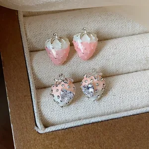 Close-up detail of pink strawberry earrings featuring heart-shaped cubic zirconia.