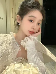 Detailed view of elegant silver bow-shaped rhinestone earrings worn by a model in soft light