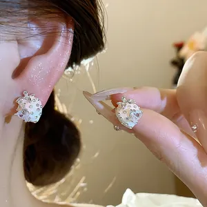 Detail view of silver needle strawberry stud earrings with pink enamel and zircon stones.