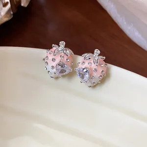 Detailed view of pink and white strawberry stud earrings with heart-shaped zircon gems