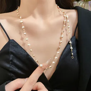 Close-up of an elegant layered acrylic glass bead necklace featuring a gold-tone chain.