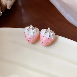 Close-up of pink dripping oil strawberry stud earrings with elegant silver leaf detail