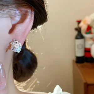 Close-up view of a delicate strawberry stud earring with sparkling zirconia stones.
