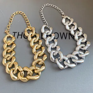 Chunky gold and silver link necklaces with adjustable chains on a gray textured background.
