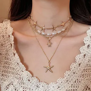 Bohemian gold layered necklace with starfish and turtle pendants and white pearls