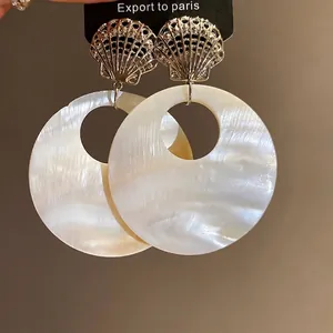 Elegante weiße Muschel-Ohrhänger mit goldenem Fächer-Detail für den Sommerurlaub Look