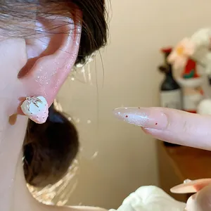 Detailed close-up view of a sweet pink strawberry stud earring worn on the ear lobe