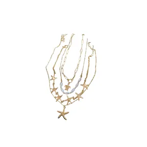 Ocean themed multi-layer gold necklace with starfish, turtle charms and white pearls.