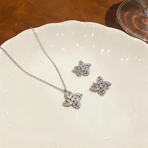Vue détaillée d'un collier pendentif fleur en zircon brillant et boucles d'oreilles