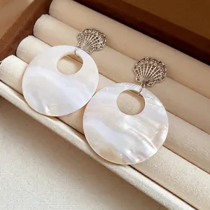 Elegante weiße Muschelohrringe mit silbernem Muscheldetail in einer Schmuckschatulle