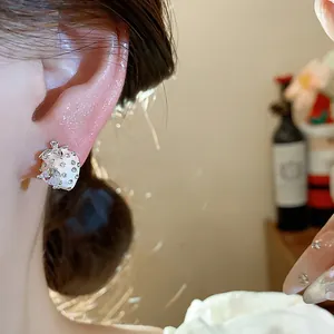 Detail view of exquisite white enamel strawberry stud earring featuring sparkling cubic zirconia