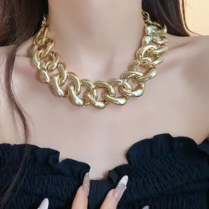 Close-up view of a luxury chunky gold curb chain necklace worn by a fashion model