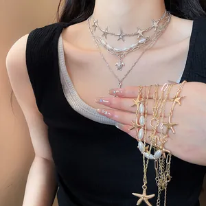 Detailed view of ocean-themed layered necklace set featuring starfish, turtle and pearls.