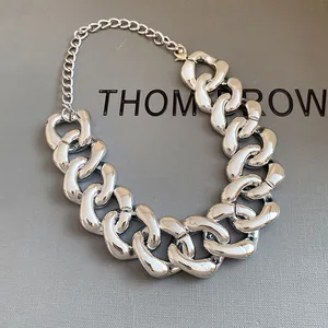 Detailed view of a chunky silver metallic chain necklace with a polished finish.