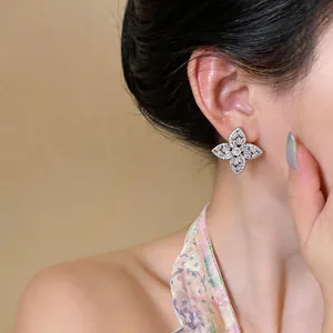 Détail de boucles d'oreilles fleurs en argent serties de zircons brillants taille baguette