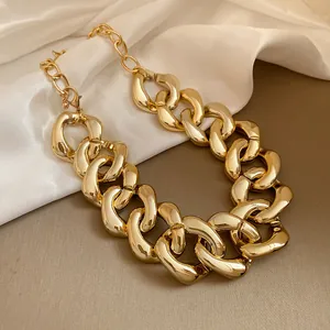 Close-up of a chunky gold-toned chain necklace with a high-gloss metallic finish