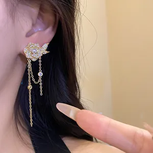 Close-up of 18K gold plated rose earrings with pearl and zircon tassel detail