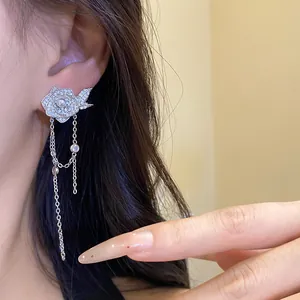 Detailed shot of a silver flower earring with pearls, zircons and long tassels