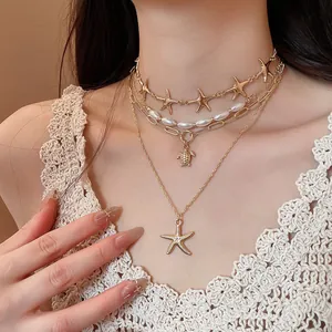 Close-up of multi-layered ocean-themed necklace with starfish and turtle pendants.