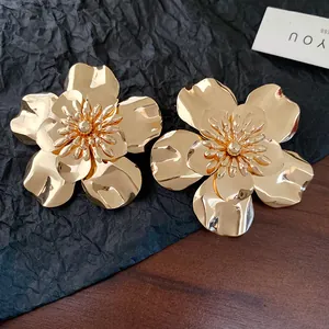 Detailed macro view of vintage gold-toned metallic flower stud earrings with layered petals