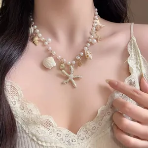 Vista dettagliata di una collana di perle con ciondoli a forma di stella marina e conchiglie