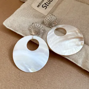 Detailansicht der runden schillernden Muschelohrringe mit silbernem Muschelstecker